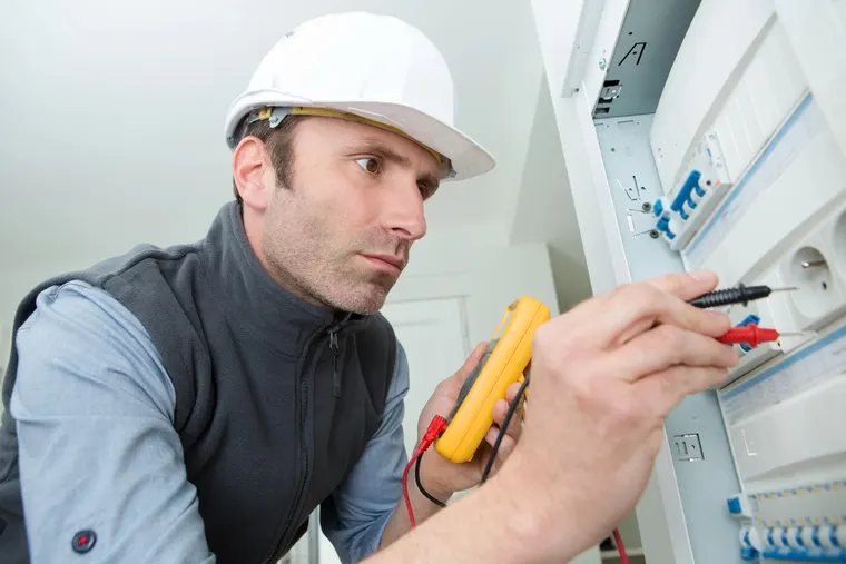 Mesure au multimètre sur une prise lors d'un dépannage électrique